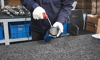 An operator cleaning a filter housing surface with an air gun